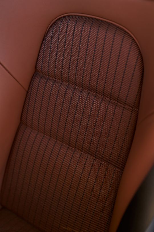 The interior features Full Bucket Seats with cloth seat centers in Classic Cognac with black pinstripes